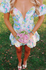 Woman in a floral dress holding a bouquet of flowers outdoors.